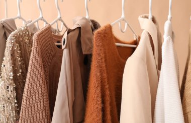 Bej arka planda şık kıyafetlerle dizin