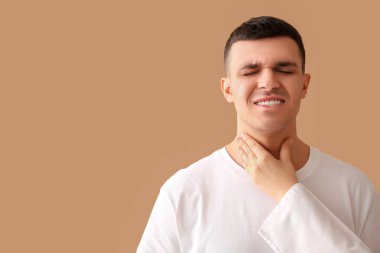 Endocrinologist examining thyroid gland of young man on beige background, closeup clipart