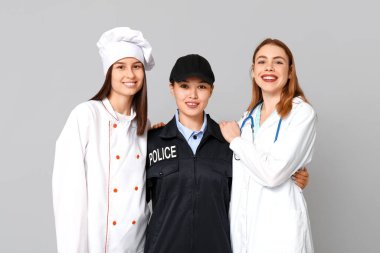 Gri arka planda farklı meslekten kadınlar