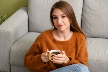 Evinde çay içen genç bir kadın.