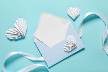 Boş kartlı kompozisyon, kağıt kalpler ve renk arkaplanlı kurdele. Sevgililer Günü kutlaması