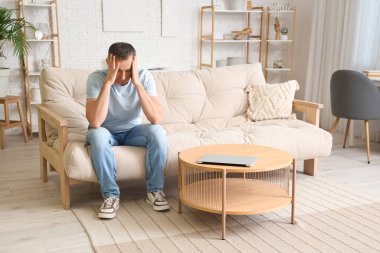 Evde migrenden muzdarip olgun bir adam.