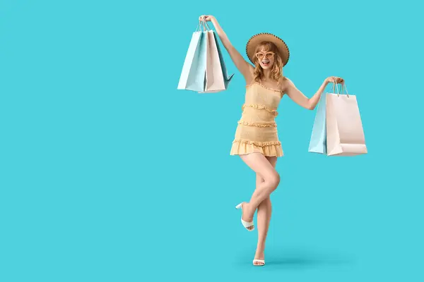 青い背景のショッピングバッグを持つ美しい幸せな若い女性 — ストック写真