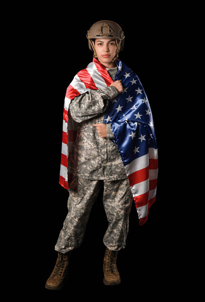 Young female soldier in uniform with flag of USA on black background