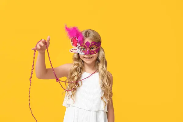 可爱的小女孩 戴着黄色背景的狂欢节面具 — 图库照片