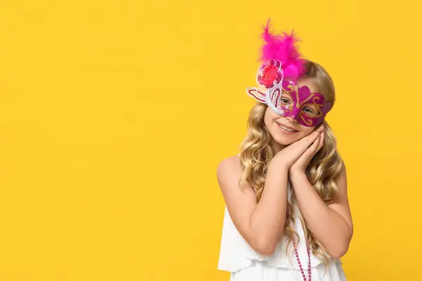 可爱的小女孩 戴着黄色背景的狂欢节面具 — 图库照片