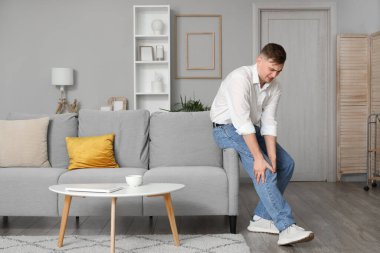 Genç adam evde diz ağrısı acı