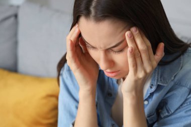 Genç kadın evde, baş ağrısı closeup acı