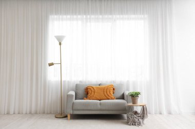 Lamba, rahat kanepe ve oturma odasındaki ışık perdesinin yanındaki sehpa.