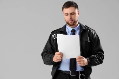 Gri arka planı olan bir erkek polis memuru.