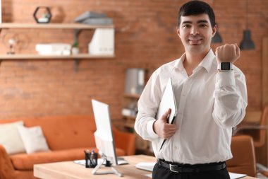 Akıllı saat ve dizüstü bilgisayarı olan genç bir iş adamı