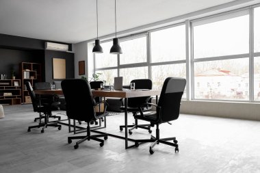 Penceresi, masası ve koltukları olan modern konferans salonu.