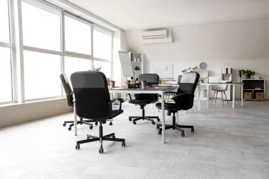 Masaları, pencereleri ve koltukları olan ışık konferans salonunun içi