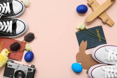 Pasaportlu ayakkabılar, kamera ve bej arka planda Paskalya dekoru. Tatil seyahati kompozisyonu