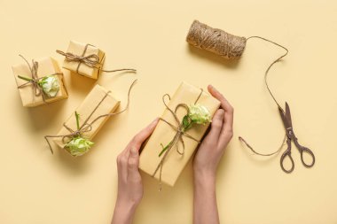 Hediye kutularıyla kadın elleri ve sarı arka planda güzel beyaz güller. Uluslararası Kadınlar Günü