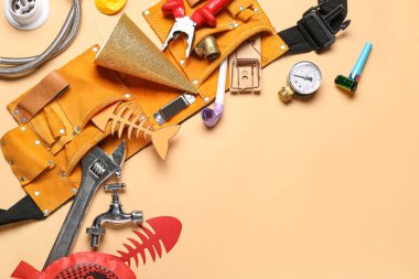 Osuruk yastığı, fare kapanı ve bej arka planda parti dekoruna sahip inşaat aletleri. 1 Nisan Şaka Günü