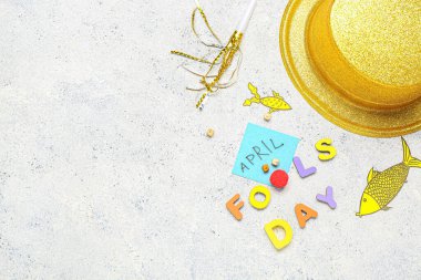 Şapka, kağıt balıkçılığı ve hafif grunge arkaplanı üzerine yapışkan notla FOOLS Day metni