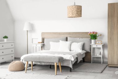 Uluslararası Kadınlar Günü için yataklı ve laleli aydınlık yatak odasının içi