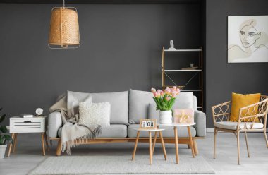 Uluslararası Kadınlar Günü için hediye kutusu ve laleleri olan oturma odasının masalarında.