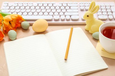 Renk arkaplanındaki boş defter, klavye ve Paskalya dekoru, kapat