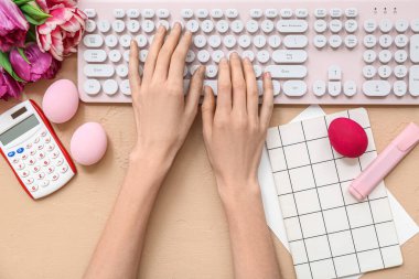 Modern klavye, kırtasiye ve paskalya yumurtalarına sahip kadın elleri, yakın plan.