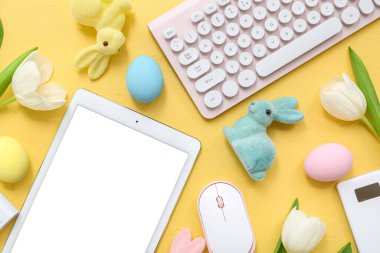 Renk arkaplanında modern cihazlar ve Paskalya dekoru olan kompozisyon