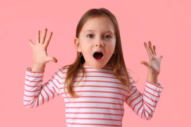 Şok olmuş küçük kız pembe arka planda