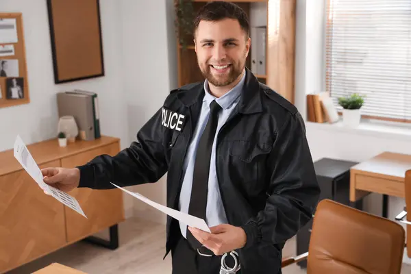 Male police officer with documents in office