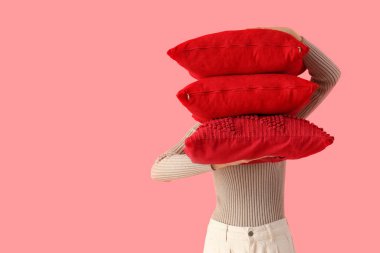 Pembe arka planda kırmızı yastıklı kadın