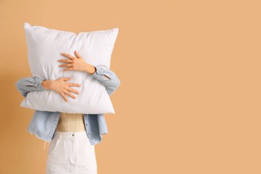 Bej arka planda beyaz yastıklı kadın