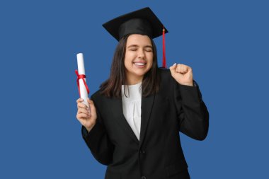 Mezuniyet şapkalı mutlu bayan öğrenci ve mavi arka planda diploması var.