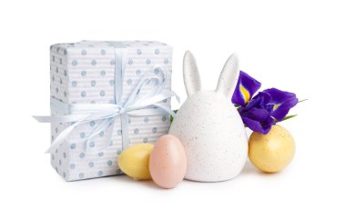 Paskalya yumurtaları, süsen çiçekleri ve beyaz arka planda hediye.
