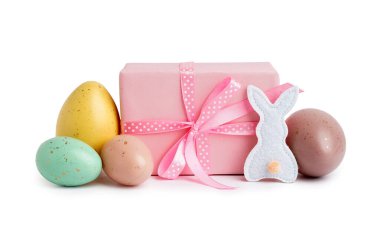 Paskalya yumurtaları, kumaş tavşan ve beyaz arka planda hediye.