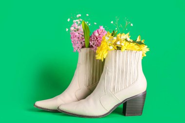 Yeşil arka planda çiçekli beyaz çizmeler