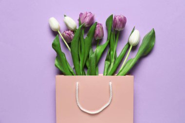 Leylak arkaplan üzerinde güzel laleler olan kağıt çanta.