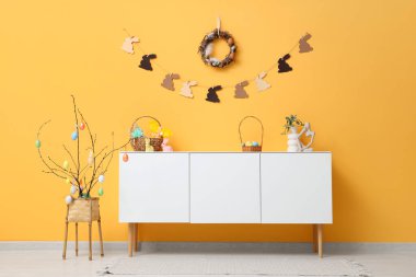 Beyaz ahşap tuvalet ve renk duvarının yanında Paskalya dekoru