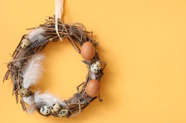 Renkli arka planda Paskalya yumurtası ve tüylü güzel bir çelenk, yakın plan.