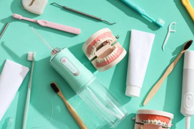 Turkuaz arka planda ağız sulandırıcı ve dişçi araçları ile ayarlandı