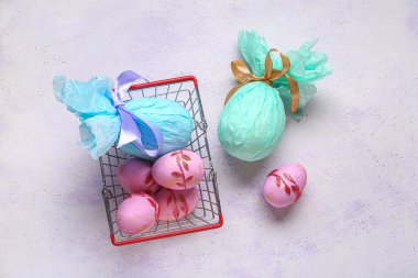 Leylak renginde Paskalya yumurtaları olan küçük bir alışveriş sepeti.