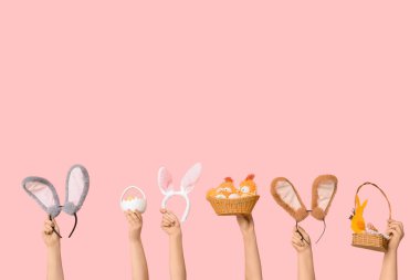 Paskalya tavşanı saçbantlı pembe arka planda sepetli kadın elleri