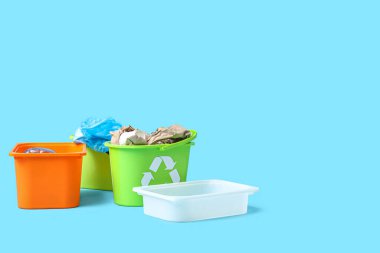 Mavi arka planda çöp kutuları. Atık sıralama kavramı