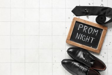 Metin PROM gecesine sahip tebeşir tahtası, erkek ayakkabıları ve beyaz karo arka planda kravat