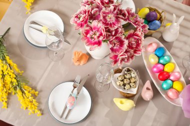 Çiçekler ve boyanmış yumurtalarla süslü Paskalya sofrası