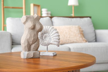 Rahat bir kanepe, dekorasyon kabuğu ve kadın cesedi oturma odasındaki sehpanın üzerinde.