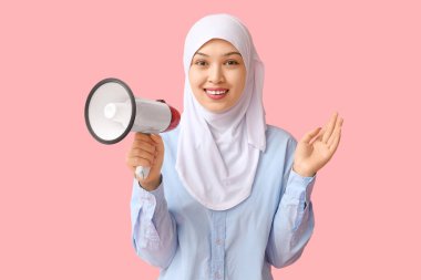 Pembe arka planda megafonu olan genç Asyalı Müslüman kadın. Ulusal Duyulma Günü