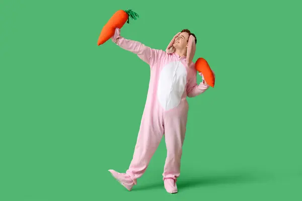 Glücklicher Junger Mann Osterhasenkostüm Mit Plüschmöhren Auf Grünem Hintergrund — Stockfoto