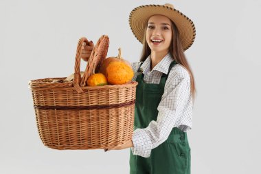 Açık arkaplanda balkabağı sepeti olan kadın çiftçi.
