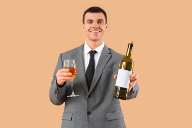 Bej arka planda cam ve şarap şişesi olan genç şarap garsonu.