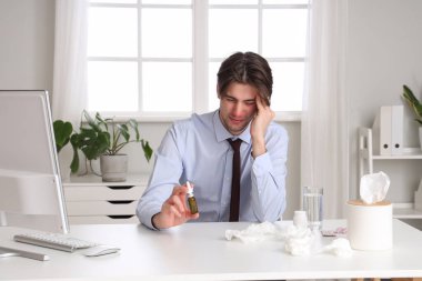 Ofiste burun damlası olan hasta bir işadamı.