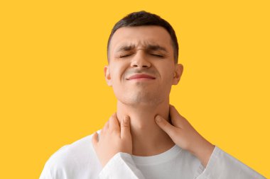 Endocrinologist examining thyroid gland of young man on yellow background, closeup clipart
